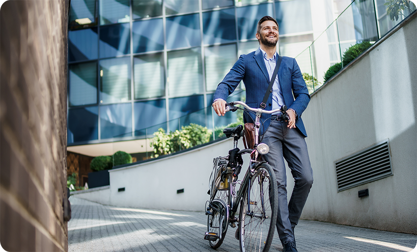 Bild Mann im Anzug schiebt sein Fahrrad und verlässt ein Bürogebäude